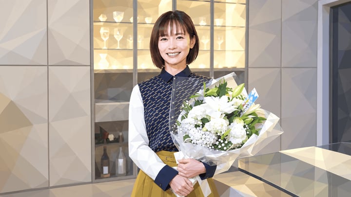 흰 꽃다발을 두 손으로 들고 실내에서 미소 짓는 나카무라 유리