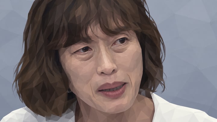 흰 재킷을 입고 회견에서 발언하는 다무라 도모코
